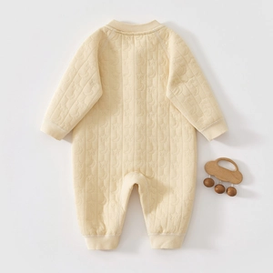 Detail of quilted cotton baby romper showing moon and star patterns with ribbed cuffs