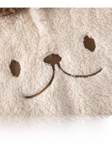 Close-up of cute bear embroidery on soft beige sherpa fleece baby winter romper