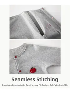 Detailed macro view of smooth flat-seam stitching and red apple patch on gray baby bodysuit