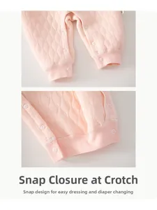 Détail d'une grenouillère matelassée rose avec boutons-pression pour changer les couches