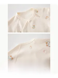Detailed view of the soft cotton neckline and snap buttons on newborn baby shirt