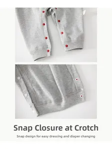 Detail of baby romper with red snap buttons on gray knit fabric for easy diaper changes