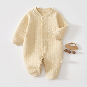 Detail of baby quilted romper showing moon and star textures with a Baby embroidery