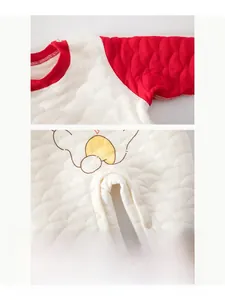 Detail of red quilted baby romper showing resin snap buttons and smile print texture