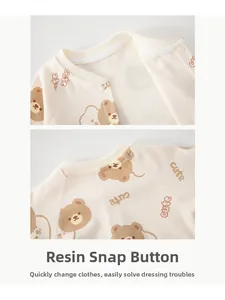 Detail eines Baby-Stramplers mit Harz-Druckknöpfen und süßem Cartoon-Bär-Print-Muster