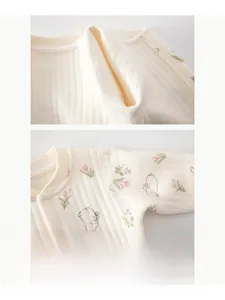 Close-up of baby romper with floral rabbit pattern and soft seamless stitching details