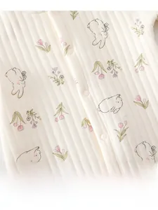 Detail view of baby romper featuring pink tulip and cute rabbit prints on ribbed cotton fabric