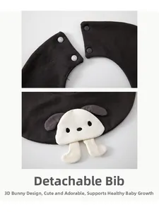 Detail of baby bib with grey snap buttons and cute white plush dog ornament