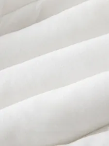 Macro detail of breathable white cotton fabric texture for baby clothes with soft folds