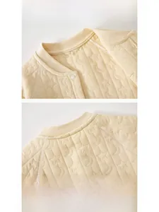 Detail of baby quilted cotton romper featuring star pattern and resin snap buttons