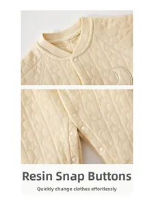 Detail of baby quilted romper featuring moon embroidery and secure resin snap buttons