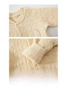 Detail of baby quilted cotton romper with star moon pattern and soft baby embroidery