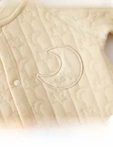Detail of baby romper featuring star and moon jacquard pattern and soft moon embroidery