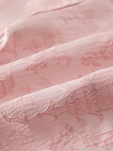 Gros plan sur un tissu jacquard rose pour bébé avec texture douce et motifs floraux fins