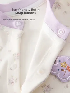 Détail de la grenouillère bébé en coton à fleurs avec boutons-pression en résine écologiques