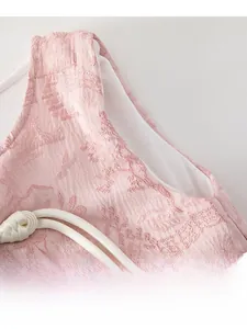 Détail de la veste rose en tissu jacquard avec un bouton traditionnel chinois blanc