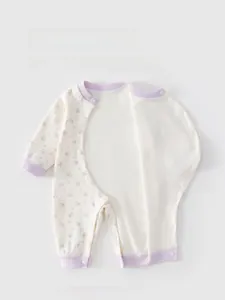 Détail d'un body pour bébé en coton avec fermeture latérale à pression et motifs
