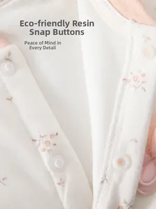 Détail d'un body pour bébé avec des boutons-pression écologiques et coton doux fleuri