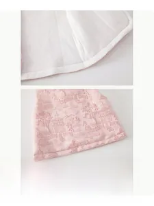 Détail du gilet rose pour bébé avec motifs chinois traditionnels et couture sans couture