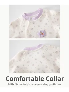Détail d'une barboteuse bébé en coton avec imprimé floral mauve et col rond côtelé
