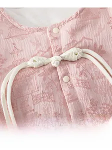 Détail du tissu jacquard rose avec motifs chinois et boutons traditionnels faits main