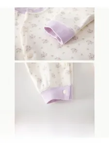 Détail d'un barboteuse bébé à fleurs montrant les poignets violets et la couture