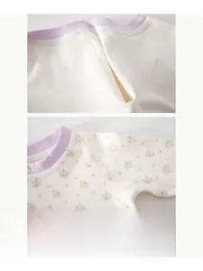 Détail d'un body bébé fleuri montrant les coutures plates et les boutons du col
