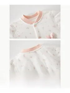 Détail d'une grenouillère pour bébé à fleurs avec col côtelé doux et boutons-pression résine