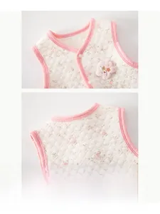 Close-up of quilted floral baby vest with decorative flower applique and soft pink trim