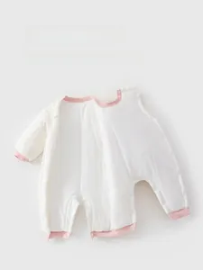 Detail of snap button closure and pink trim on padded cotton baby onesie