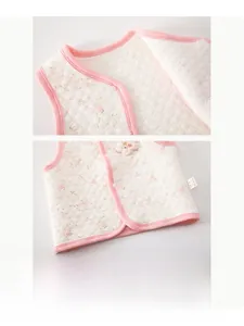 Detail of infant floral quilted vest featuring resin snap buttons and pink piping finish
