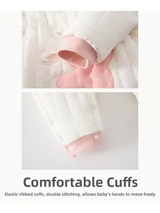 Detail of baby winter jumpsuit with pink polka dots, rabbit embroidery, and ribbed cuffs