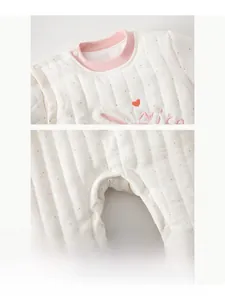 Detail of baby quilted romper showing pink polka dots and nice heart embroidery
