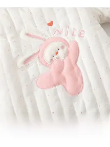 Detail of baby quilted cotton romper featuring cute pink rabbit embroidery and soft texture
