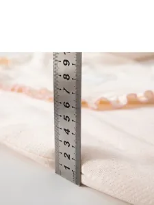 Thick off-white quilted baby romper with floral texture and pink ruffle trim