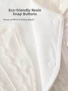 Détail macro des boutons-pression en résine écologique sur gilet tricoté pour bébé