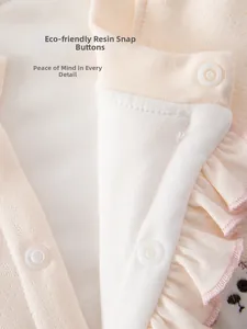 Detail of eco-friendly resin buttons and ruffle hem on baby quilted cotton romper