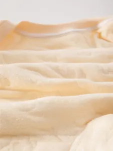 Close-up of baby romper fabric showing soft quilted texture and breathable knit details