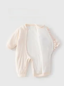 Detail view of baby cotton romper with pink ruffles and side snap buttons closure