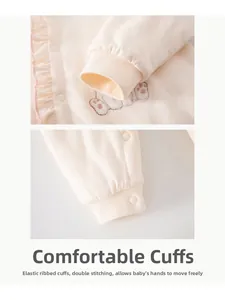 Detail of baby romper with elastic ribbed cuffs and delicate bear embroidery