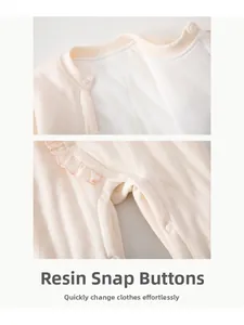 Detail of infant romper featuring resin snap buttons and elegant pink ruffled collar trim