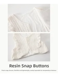 Détail d'un gilet en tricot pour bébé avec boutons-pression en résine et volants