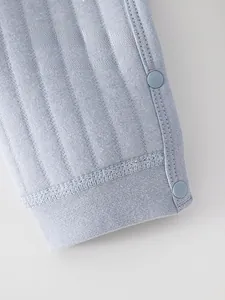 Macro detail of baby thermal cotton pants featuring ribbed fabric and snap buttons