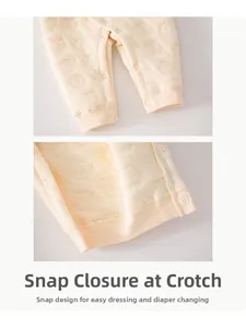 Detail of snap button crotch on thickened beige baby romper with embossed elephant texture