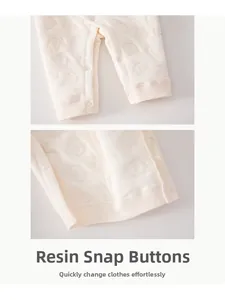 Détail de la barboteuse en coton avec boutons-pression en résine et motif éléphant