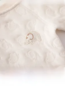 Détail d'une grenouillère bébé en coton avec jacquard d'éléphants et broderie douce