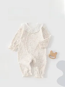 Détail de barboteuse en coton pour nouveau-né avec col en dentelle et motif floral