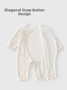 Détail de grenouillère bébé en coton fleuri avec col dentelle et boutons pression