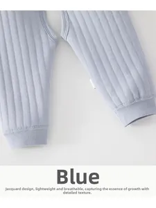 Détail du pantalon bleu pour bébé avec texture jacquard, entrejambe ouvert et bords-côtes