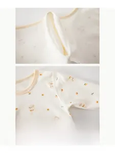 Detail of baby cotton onesie featuring smooth flatlock seams and cute cartoon bear print